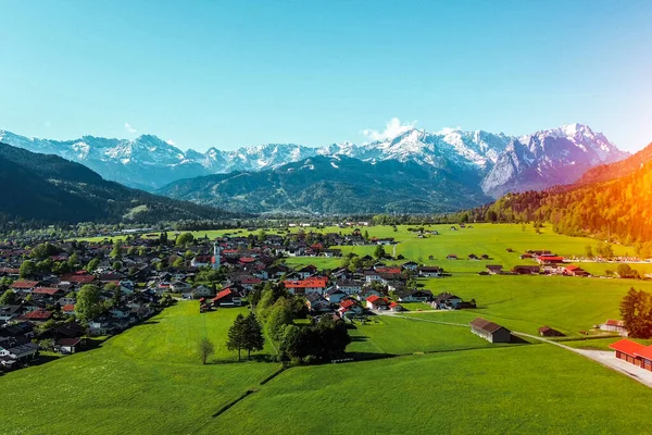 Kırmızı çatıları ve dağları olan yemyeşil bir kırsal.