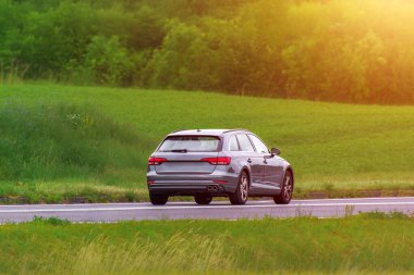 Steyşın vagon, canlı yeşil yaprakların yanından geçiyor.