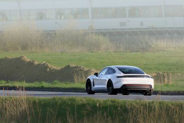 Modern elektrikli araba ülke otoyolunda gidiyor.