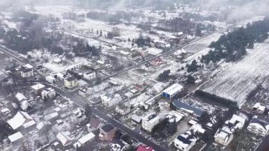 Beyaz kar altında küçük kasaba sokaklarının insansız hava aracı görüntüleri.
