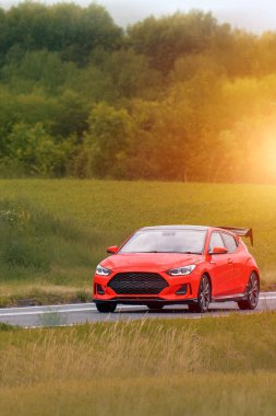 Kırsalda gezen kırmızı spor bir coupe.