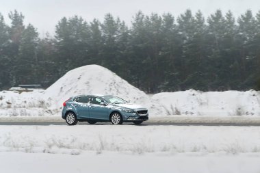 Araba kışın kırsal yolda gidiyor.