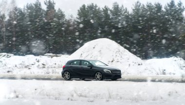 Lüks otomobil kış havasında yol alıyor.