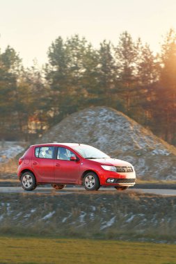 Açık yolda küçük kırmızı spor araba.