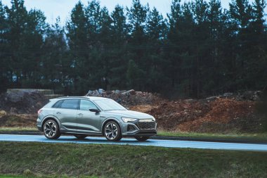 Doğada ıslak kırsal yolda giden çapraz bir araç.