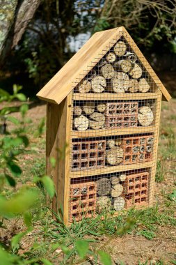 Ağaç kütükleri ve tuğlalarla dolu bir böcek barınağı