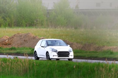 Köy yolunda park halindeki ekonomik araba.