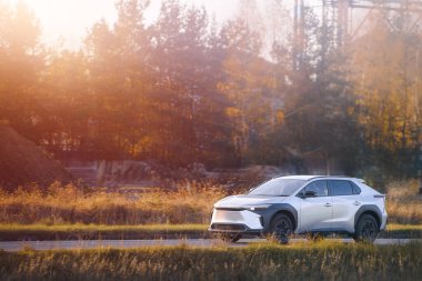 Beyaz SUV elektrikli araba dışarı çıkıyor.