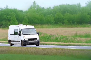 Boş köy yolunda beyaz nakliye aracı