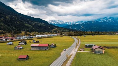 Bulutlu gökyüzünün altındaki renkli alp köyü