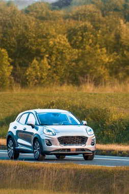 Crossover SUV açık kırsal yolda seyahat ediyor.