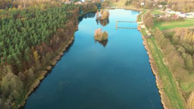 Güzel sonbahar yaprakları sakin mavi sulara yansıyor.