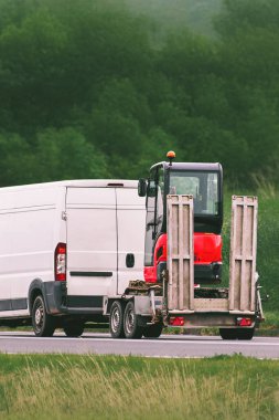 Ticari kamyonlar yolda mühendislik araçlarını hareket ettiriyor.