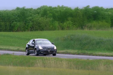 Küçük şehir arabası asfalt boyunca hızla ilerliyor.