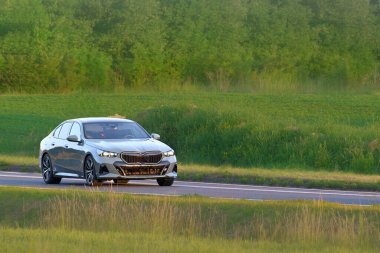 Modern şirket sedanı kırsal yolda süzülüyor