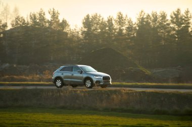 Akşam karanlığında kırsalda pahalı bir araba.