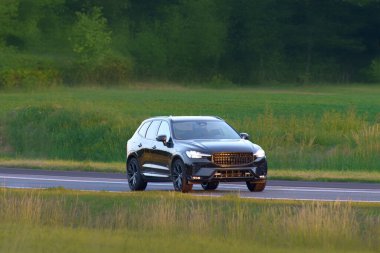 İsveç SUV 'si yeşil kırsal alanda geziniyor.