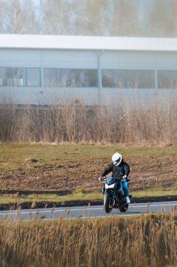 Motosikletle çimenli araziyi geçen kişi