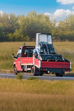 Flatbed karavanları ağır inşaat araçları taşıyor.