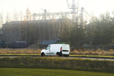 Manzaralı kırsal yolda giden minivan.