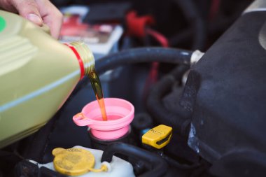 Araç motoruna yağ dökülüyor.