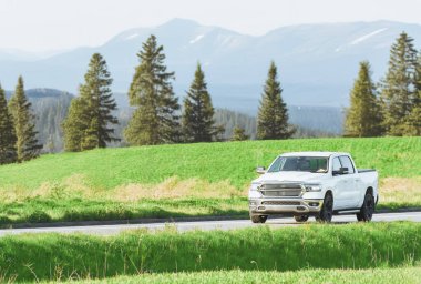 Modern beyaz kamyon kırsalda sürüyor.