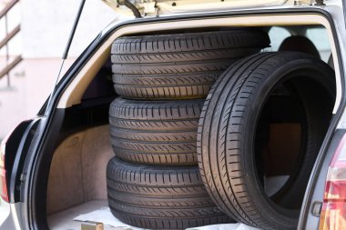 SUV bagajında yeni araba lastikleri var.