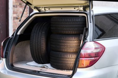 Açık arabanın bagajında yazlık lastikler var.