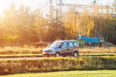 Kargo aracı ormanın yanından geçiyor.