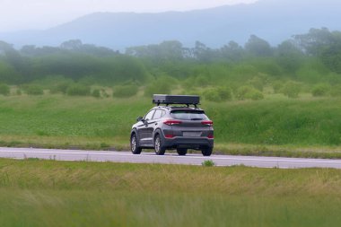 Çatı katında çadırı olan bir kamp arabası kırsal bölgeyi araştırıyor.