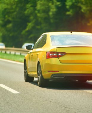 Sarı araba otoyolda gidiyor.