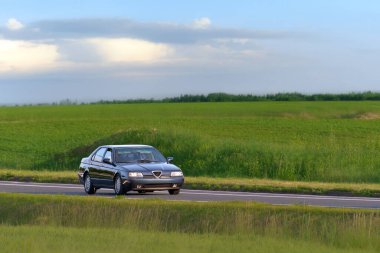 Kırsal yolda eski ama altın koleksiyonu yapan araba.