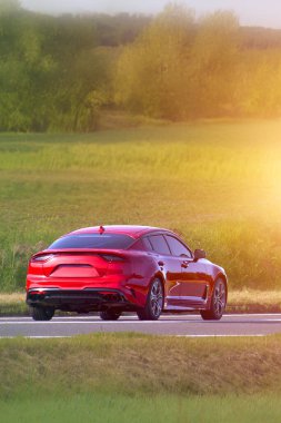 Doğal ortamda giden zarif kırmızı araba.