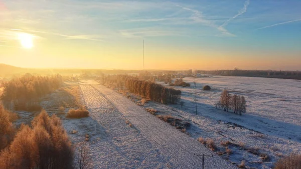 Sıcak gündoğumunun dokunduğu karlı kırsal bölge