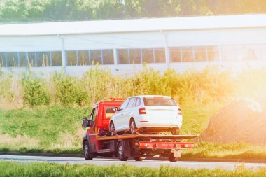 Çekici beyaz sedan taşıyor.