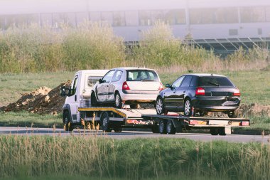 Çekici yolda bozuk araba taşıyor.