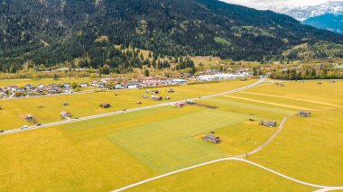 Karlı tepeleri olan yeşil dağlık arazi ve orman
