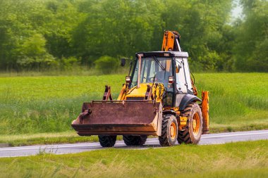 Yeşil kırsaldan geçen yol yapım aracı