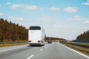 Beyaz yolcu otobüsü kırsaldan geçiyor.