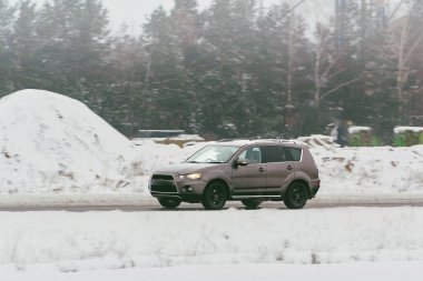 Kış manzarasında karda araba sürüyor.