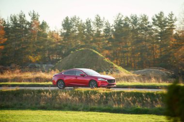 Doğadan geçen kırmızı spor sedan.