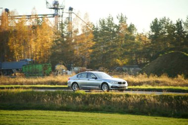 Araba çimenli tepelerden geçiyor.