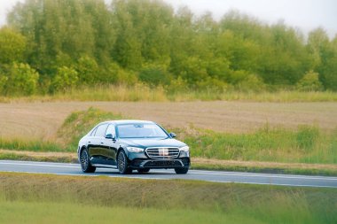 Şehir otoyolu boyunca giden lüks bir araç.