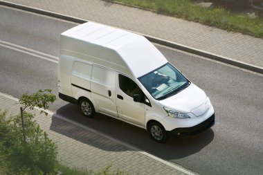 Doğayla çevrili bir yolda giden lojistik araç.