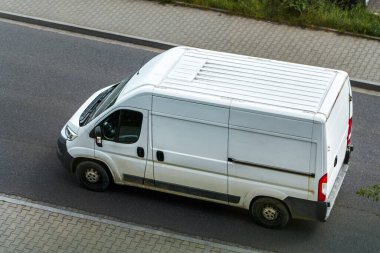 Kırsal bir sokakta sanayi nakliye aracı hareket halinde.