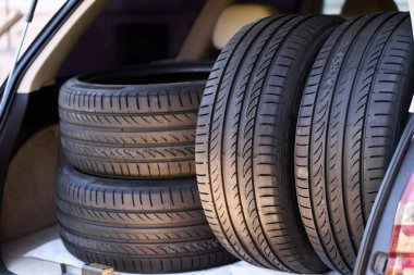 Açık arabanın bagajında yazlık lastikler var.