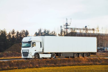 Kırsal alanda yarı karavan sürüyor.