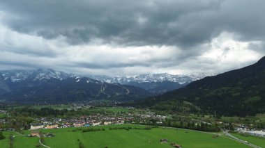 Dramatik bulutlu dağların altındaki kırsal kasaba