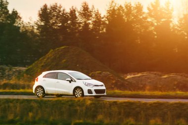 Ülke yol görünümünde küçük hatchback geziniyor