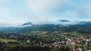 Gün doğumunda gökyüzünün altında sisli manzaralı dağ çayırı